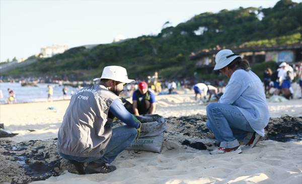 Profissionais trabalhando na manutenção das praias após o vazamento - Foto: Agência Brasil