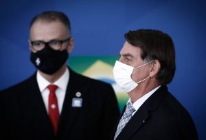 O presidente Jair Bolsonaro, durante cerimônia no Palácio do Planalto, com o presidente da Anvisa, Antônio Barra Torres, ao fundo - Foto: Pablo Jacob/Agência O Globo